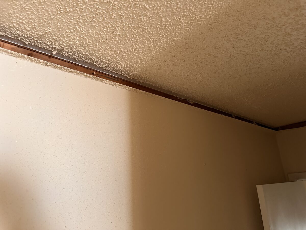 Wood trim separating from the ceiling as walls shift in a home with foundation movement