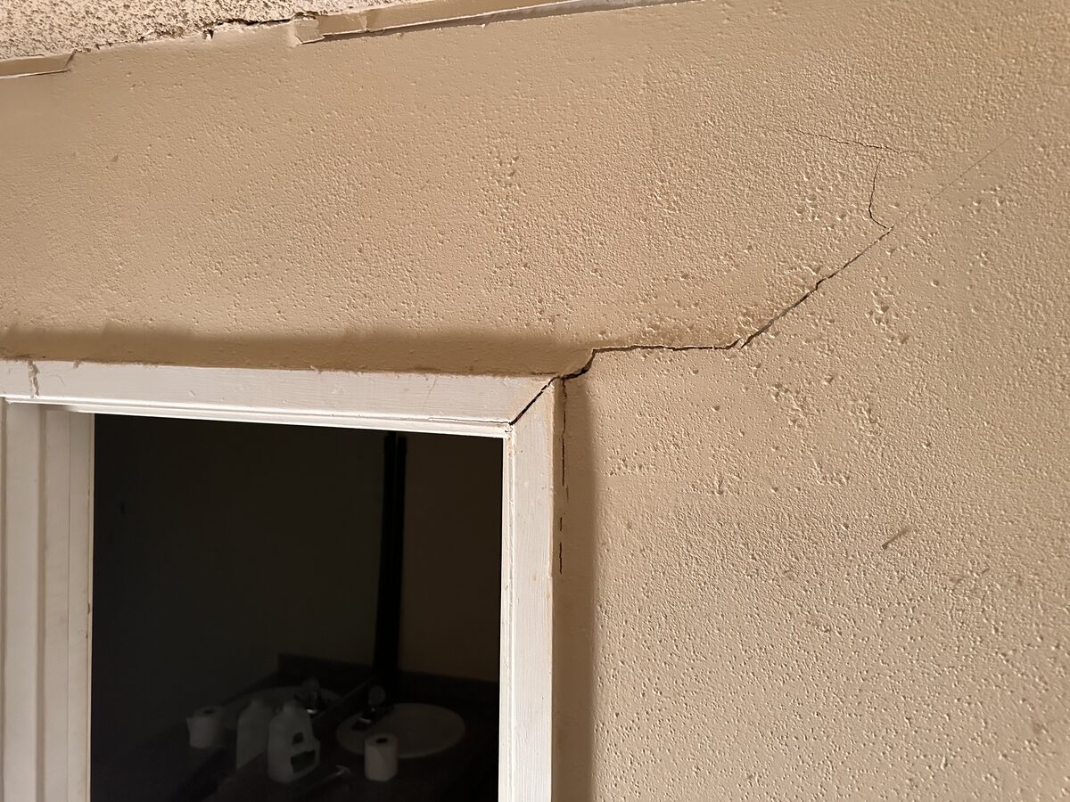 Cracks radiating from a window corner toward the ceiling, a common foundation warning sign