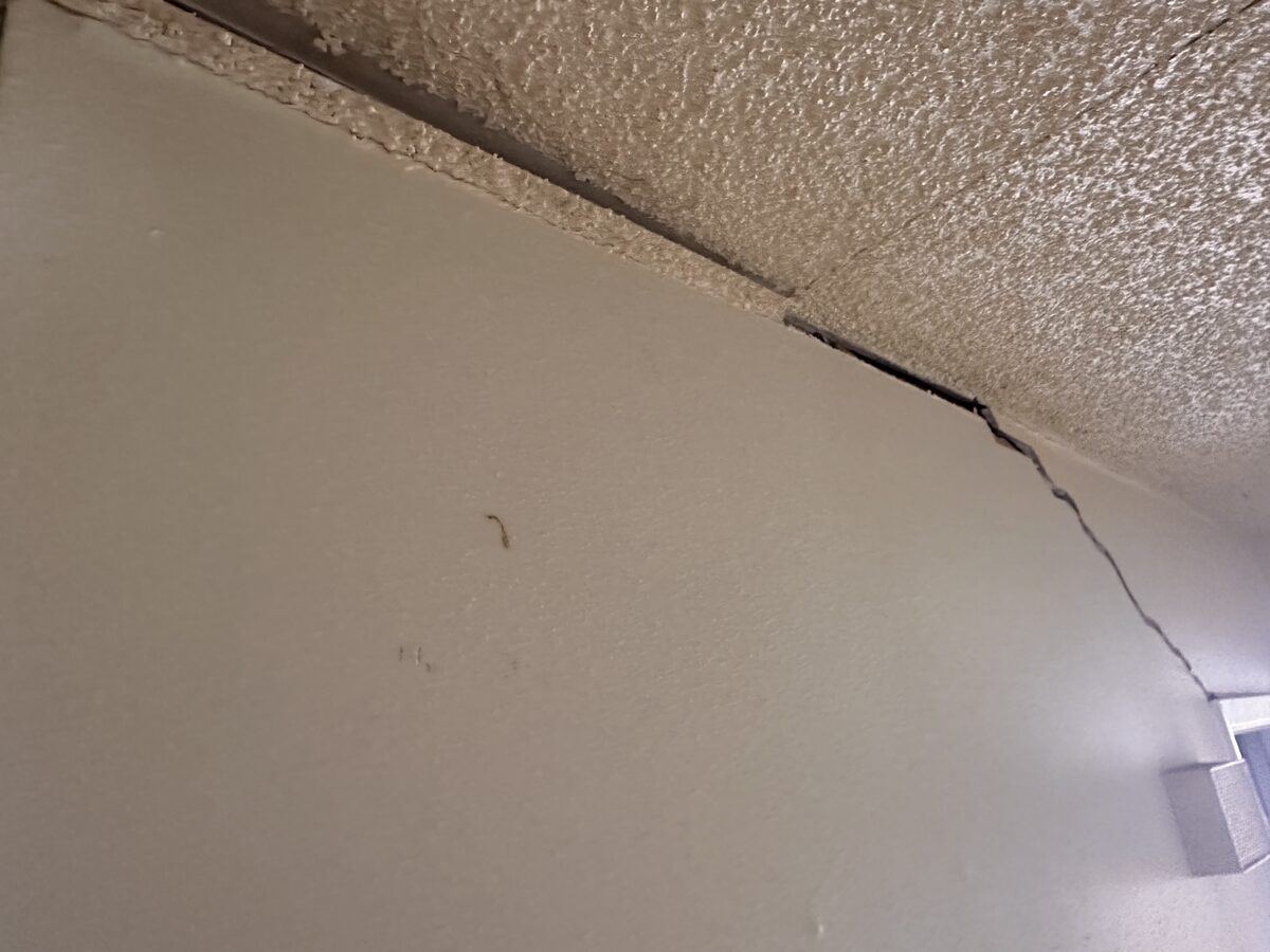 Faint diagonal crack near the ceiling of an interior wall, noted during a foundation evaluation