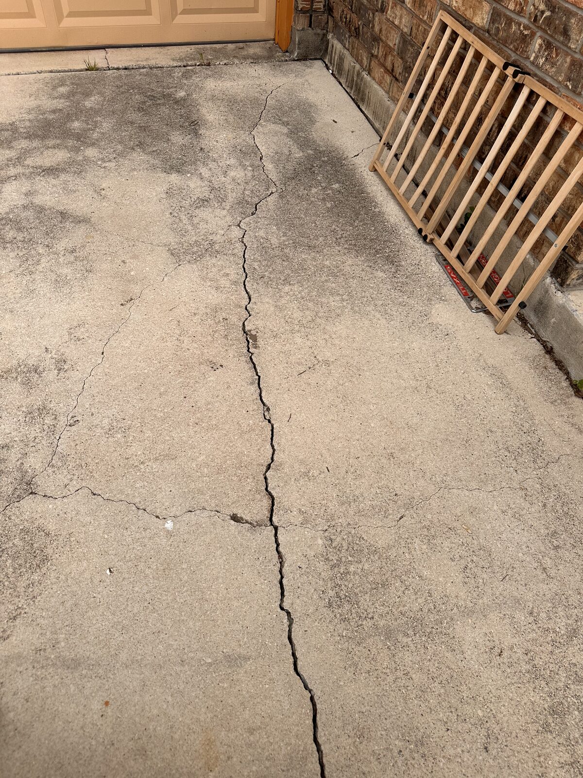 Hairline crack running the length of a concrete driveway, checked during a foundation assessment