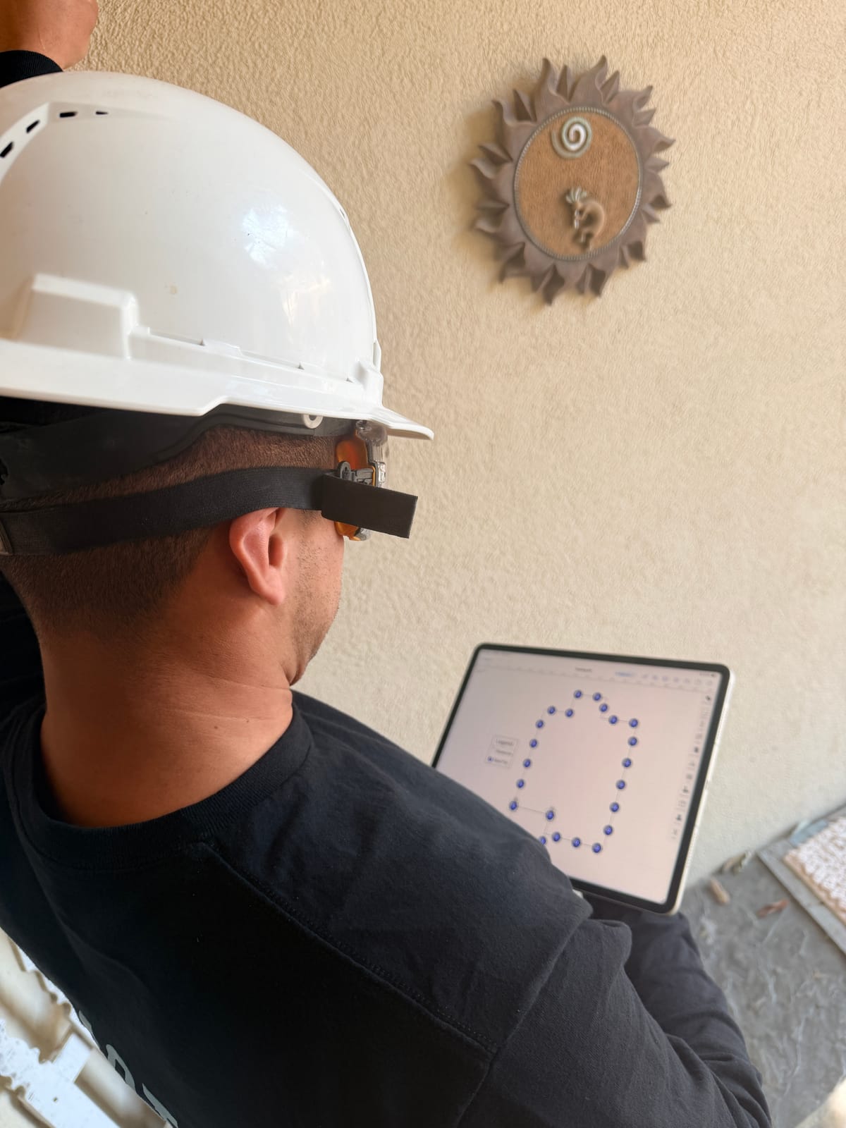 A Motmot Foundation Repair team member inspecting the exterior of a Central Texas home