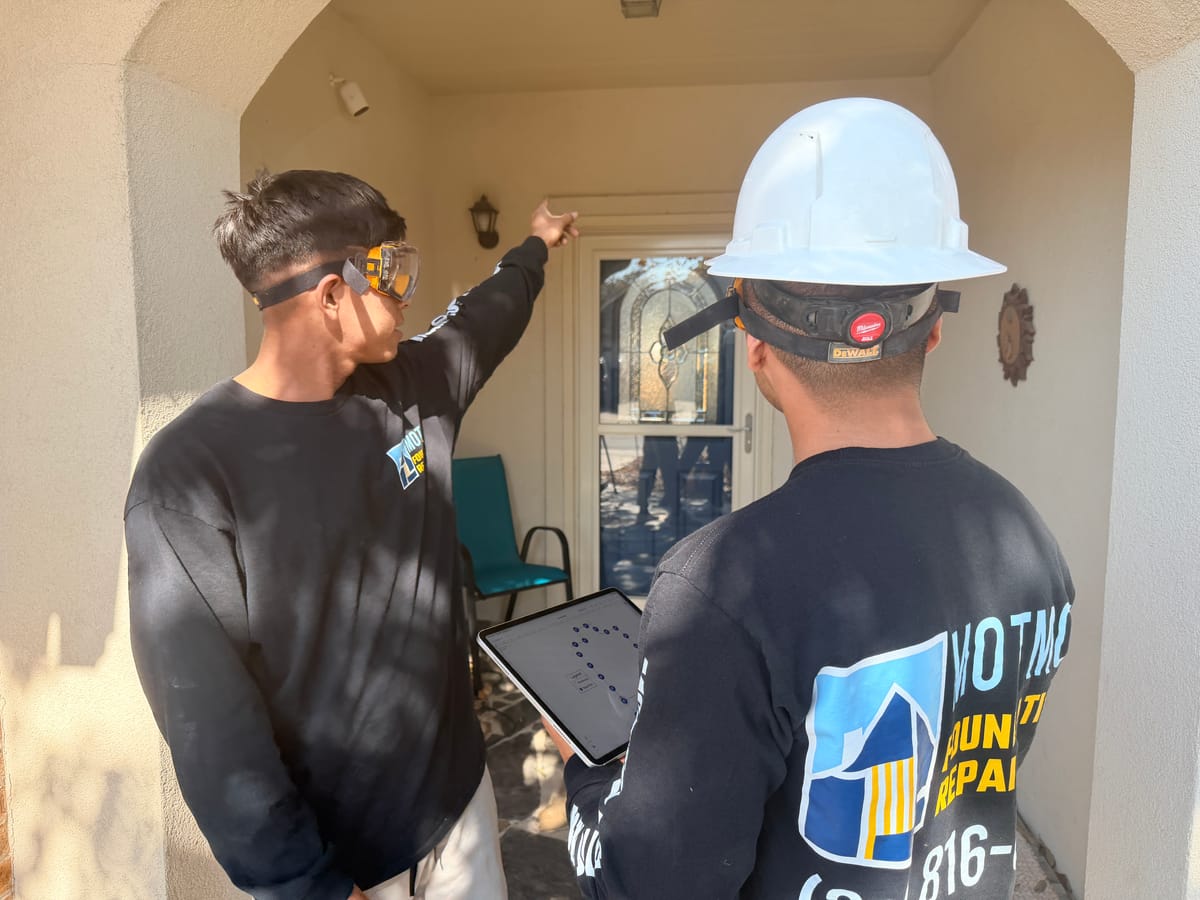 A Motmot Foundation Repair specialist inspecting a Central Texas home before recommending a repair method