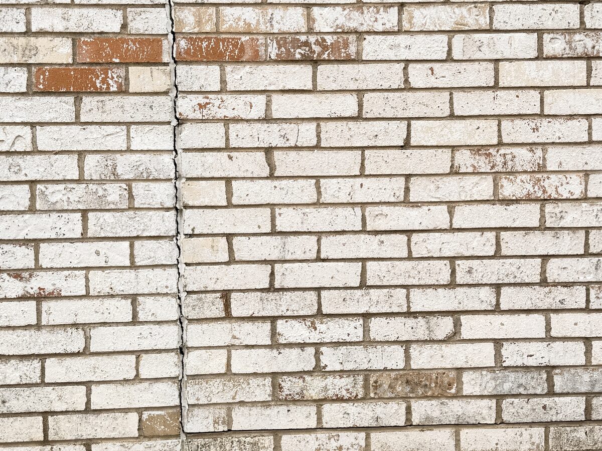Closeup of fresh mortar and replacement bricks where a settlement crack was repaired in a brick wall