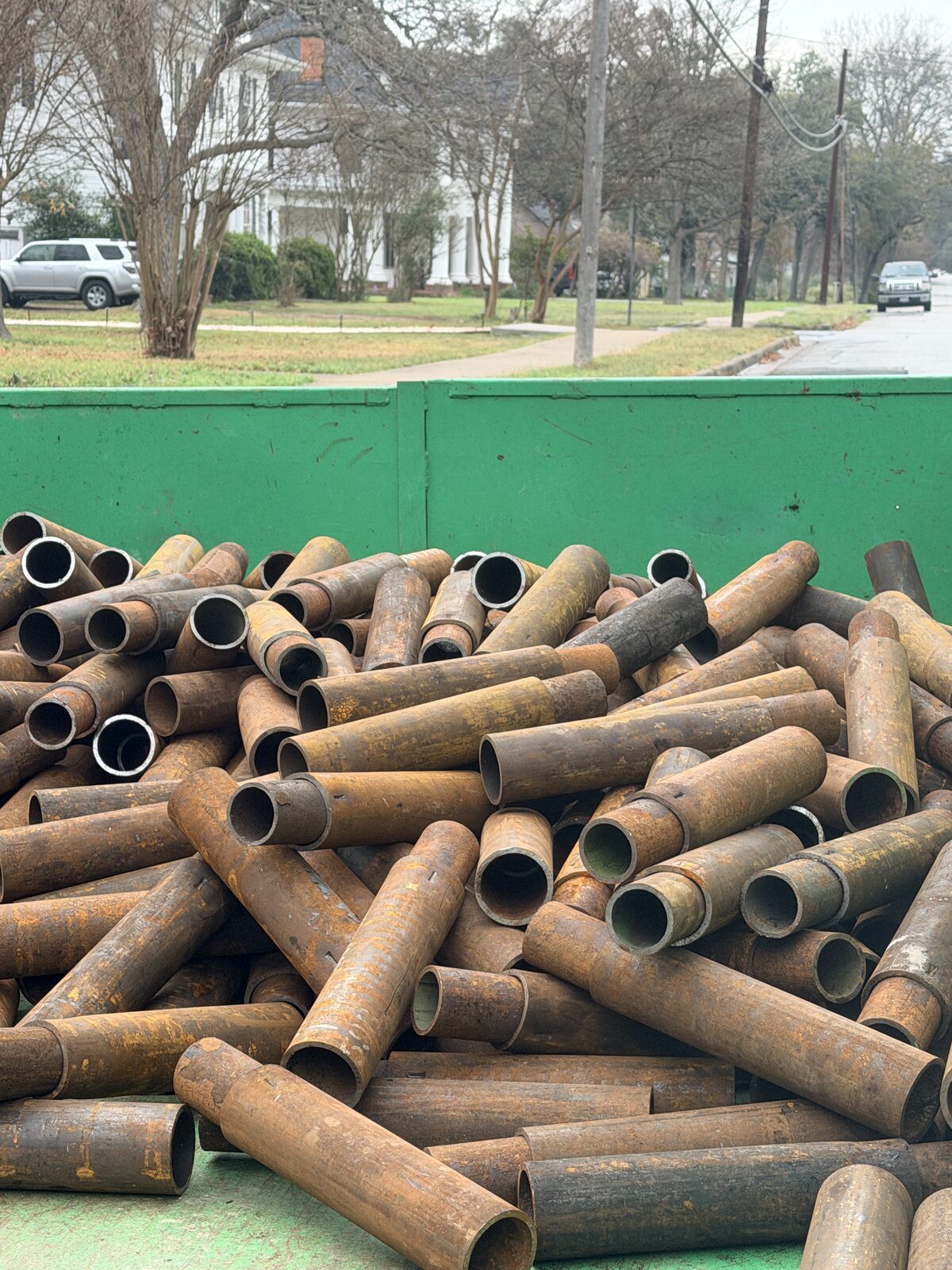 Close-up of steel pier pipe segments stacked in a trailer before foundation pier installation